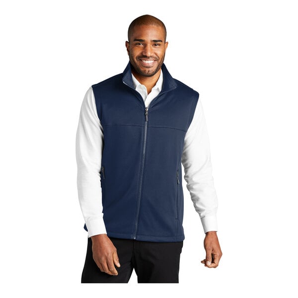 A man wearing a Port Authority navy blue fleece vest.