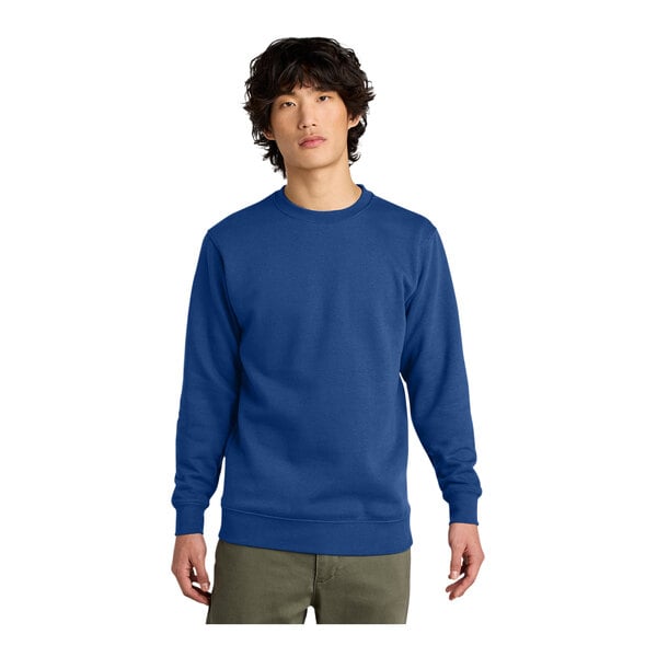 A man wearing a District deep royal blue fleece crewneck sweatshirt.