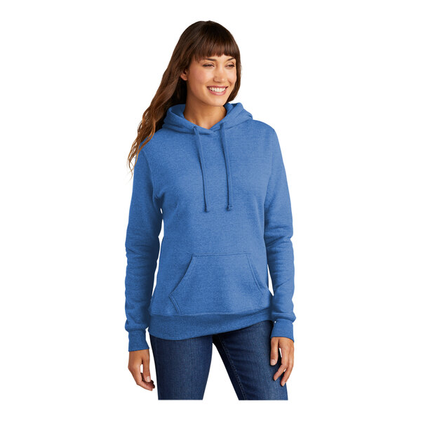 A woman wearing a Port & Company heather royal blue pullover hoodie.