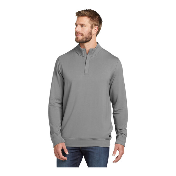 A man wearing a TravisMathew grey fleece quarter-zip pullover.