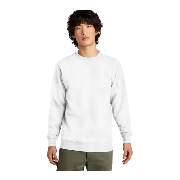 A man wearing a white District fleece crewneck sweatshirt.