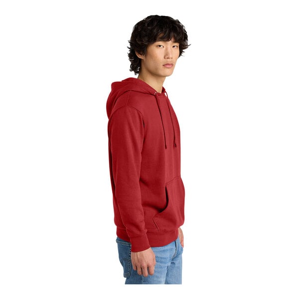 A person wearing a red District sweatshirt hoodie.