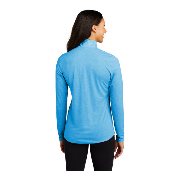 A woman wearing a Sport-Tek Pond Blue Heather quarter-zip pullover sweatshirt.