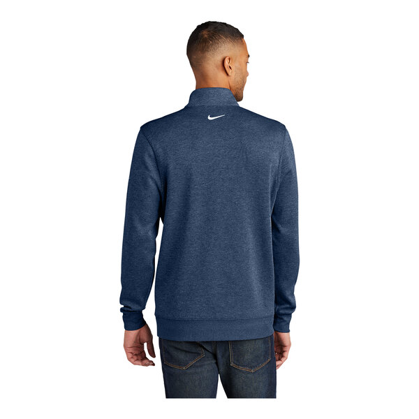 A man wearing a Nike navy blue Dri-FIT half-zip sweater with a white swoosh on the back.