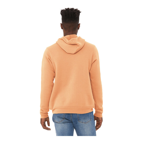 A man wearing a peach Bella + Canvas sponge fleece hoodie.