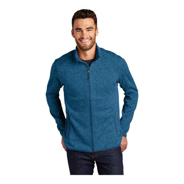 A man wearing a medium blue Port Authority fleece sweater jacket with a zipper.