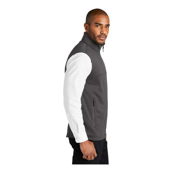 A person wearing a Port Authority graphite fleece vest.