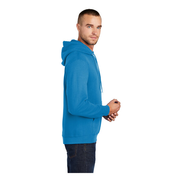 A person wearing a Port & Company Sapphire Core Fleece pullover hoodie in blue.