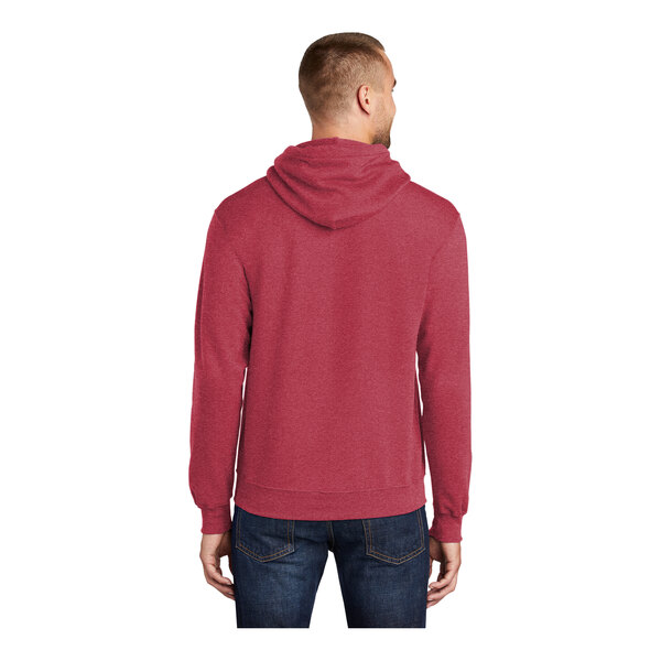 A man wearing a heather red Port & Company core fleece pullover hoodie.