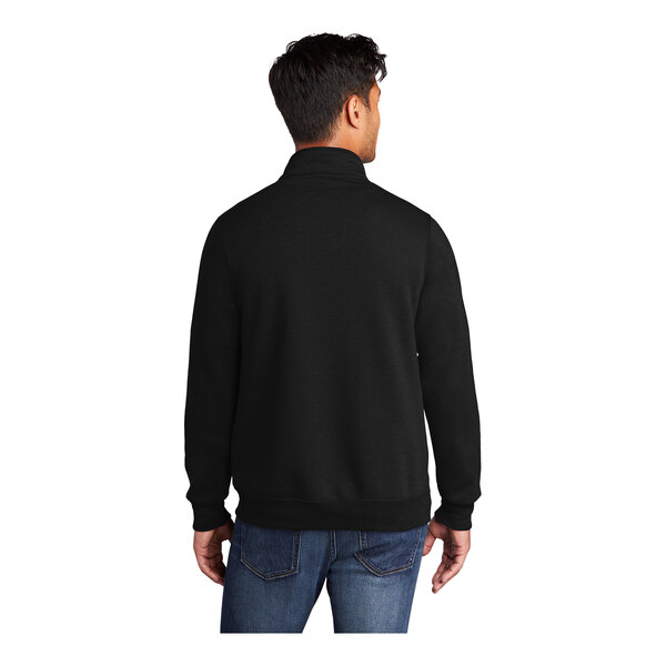 A man wearing a black Port & Company core fleece quarter-zip pullover sweatshirt.