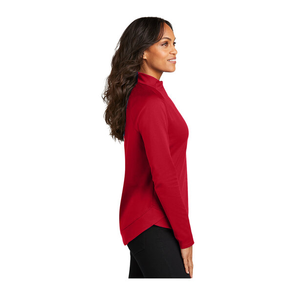 A woman wearing a red Port Authority quarter-zip sweatshirt.
