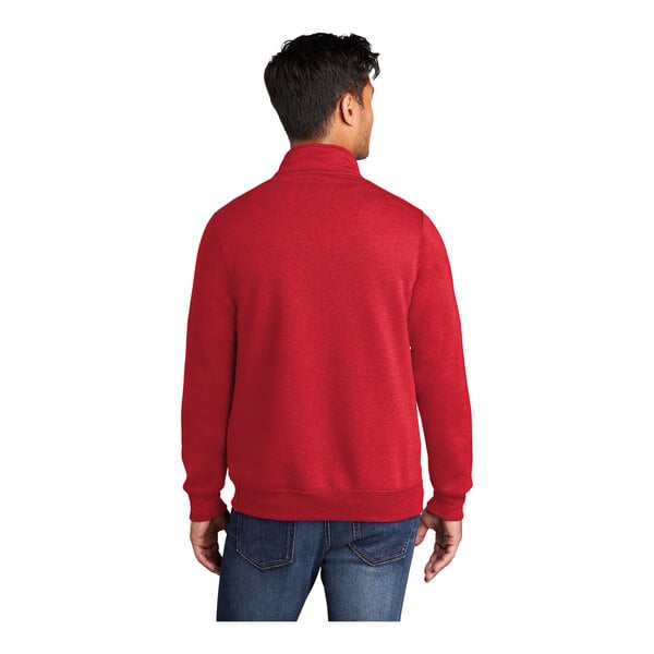 A man wearing a red Port & Company quarter-zip sweatshirt.