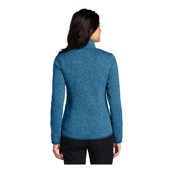 A woman wearing a Port Authority medium blue heather fleece sweater jacket.
