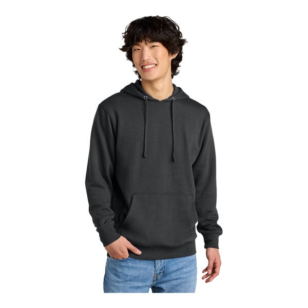 A man wearing a charcoal District sweatshirt with a hood.