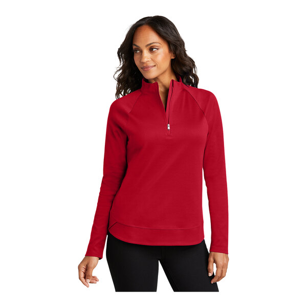 A woman wearing a Port Authority red quarter-zip sweatshirt.