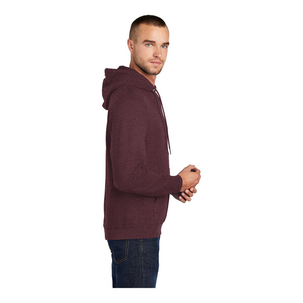 A person wearing a Port & Company heather athletic maroon core fleece pullover hoodie.