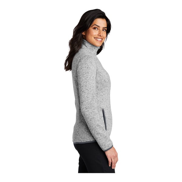 A woman wearing a Port Authority gray fleece sweater jacket.