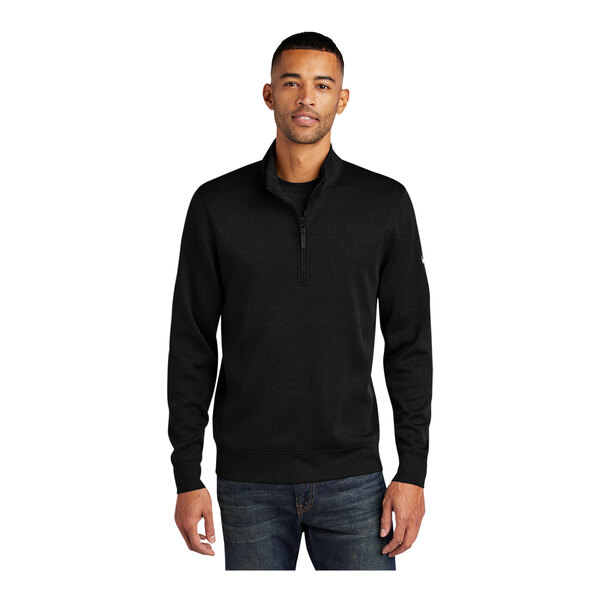 A man wearing a black Nike Dri-FIT half-zip sweater.