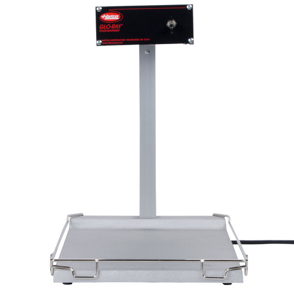 A black and white rectangular Hatco food warmer with a metal bar above it.