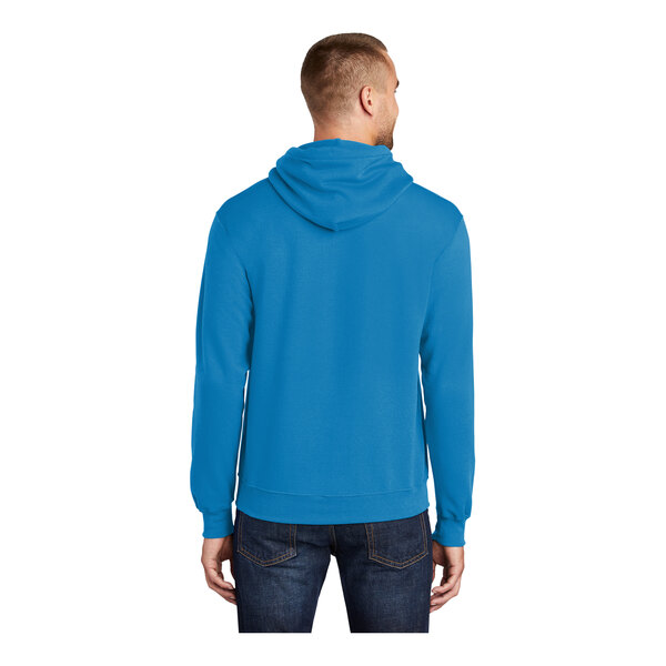 A man wearing a Port & Company Sapphire core fleece pullover hoodie in blue.