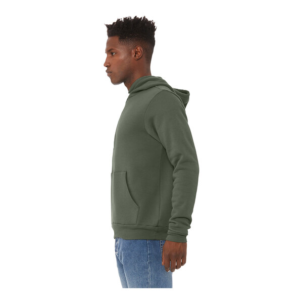 A person wearing a military green Bella + Canvas sponge fleece pullover hoodie.