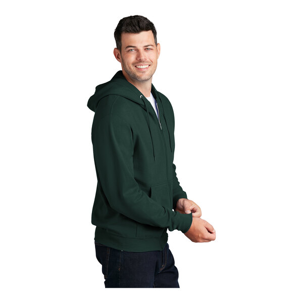 A man wearing a dark green Port & Company full-zip hoodie.