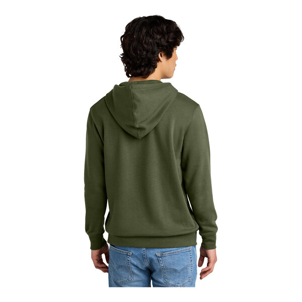 A person wearing a green District sweatshirt with a hood.