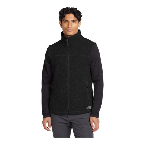 A man wearing a black The North Face fleece vest.