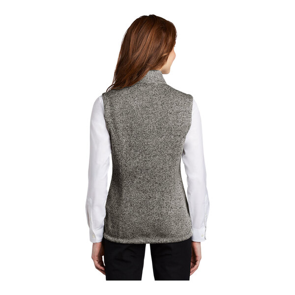 A woman wearing a gray heather wool blend fleece sweater vest.