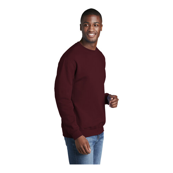 A man wearing a maroon Port & Company core fleece sweatshirt.