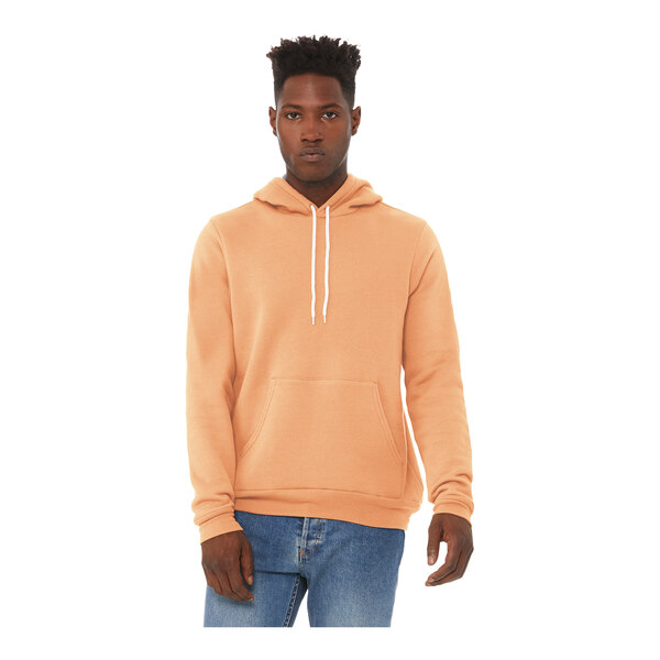 A man wearing a peach Bella + Canvas hoodie and jeans.