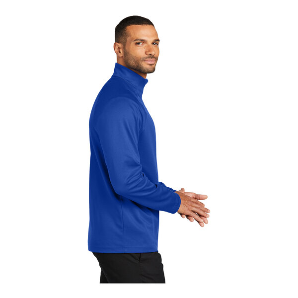 A man wearing a Port Authority blue and black quarter-zip sweatshirt.