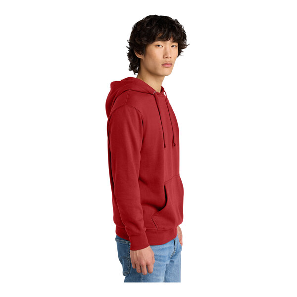 A man wearing a red District sweatshirt hoodie.
