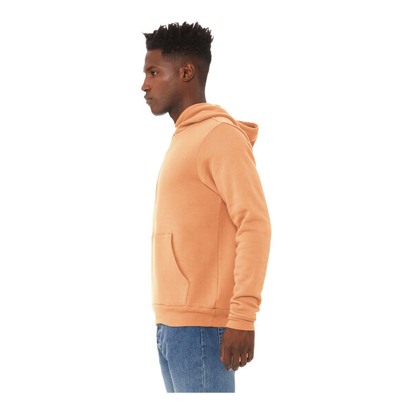 A man wearing a peach Bella Canvas hoodie.