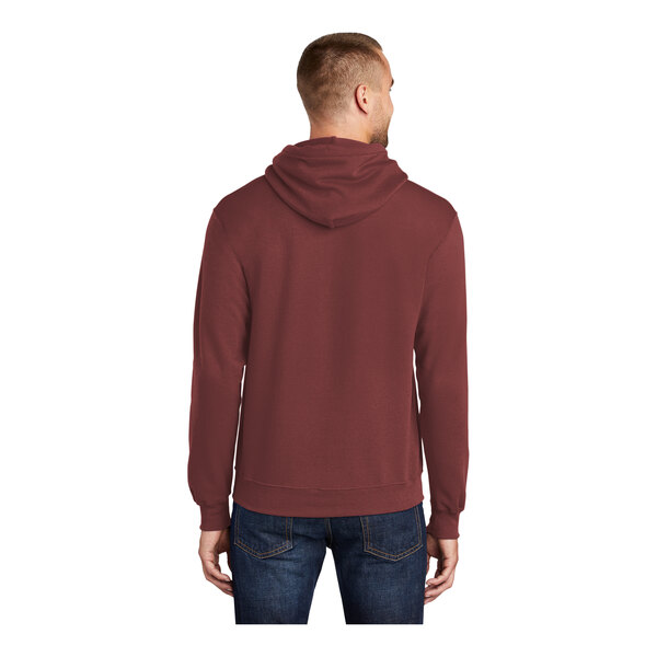 A person wearing a maroon Port & Company Core Fleece pullover hoodie.