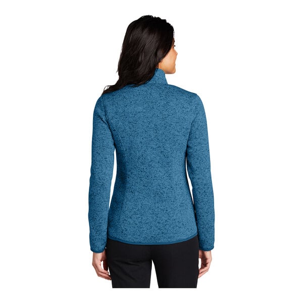 A woman wearing a Port Authority medium blue heather fleece sweater jacket.