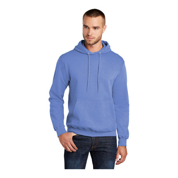 A man wearing a Carolina blue Port & Company pullover hoodie.