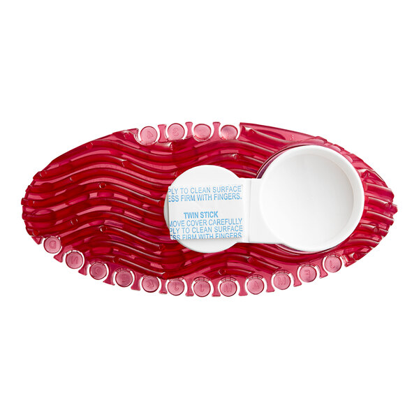 A close-up of a red oval shaped container with a white circle on it containing spiced apple scented gel.