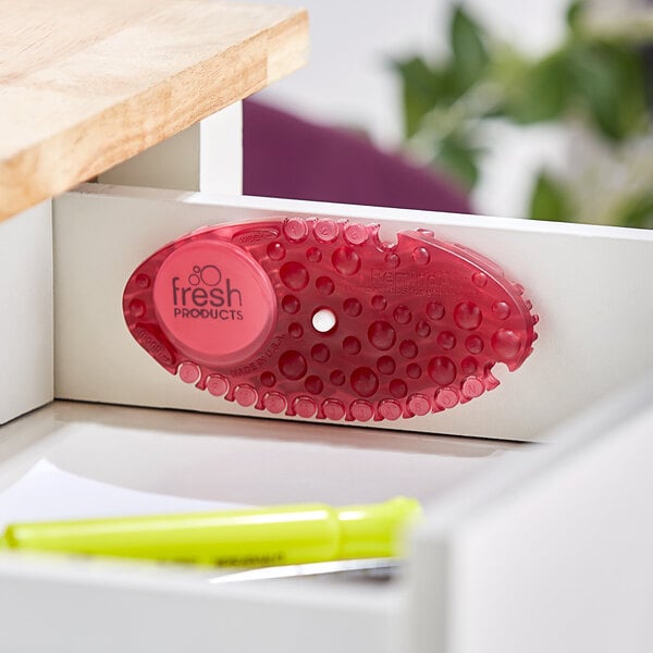 A red Fresh Products Curve air freshener holder on a table.