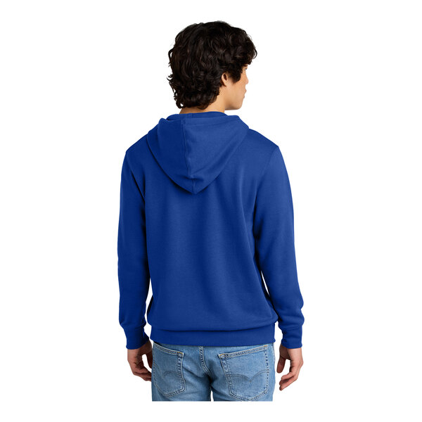 A man wearing a deep royal blue District sweatshirt with a hood.