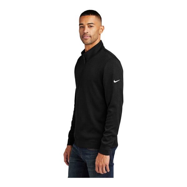A man wearing a black Nike Dri-FIT half-zip sweater.