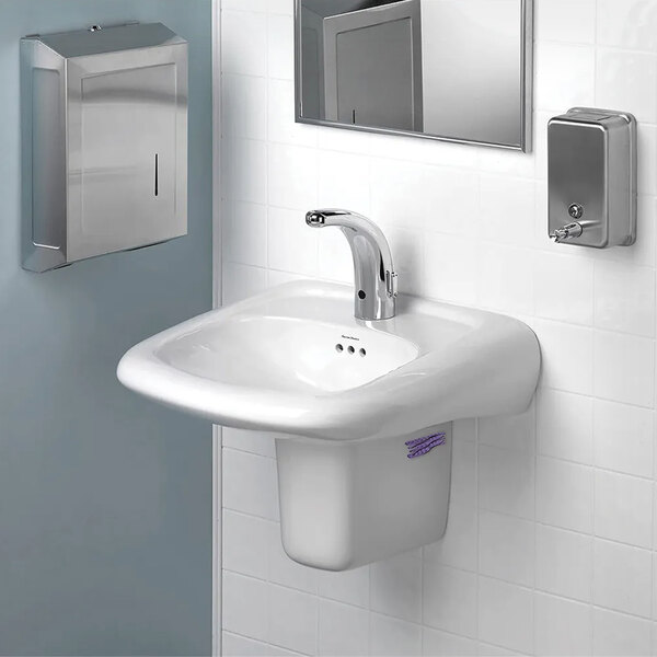 A white sink with a silver faucet and a WizKid Current Lavender air freshener on the counter over the sink.