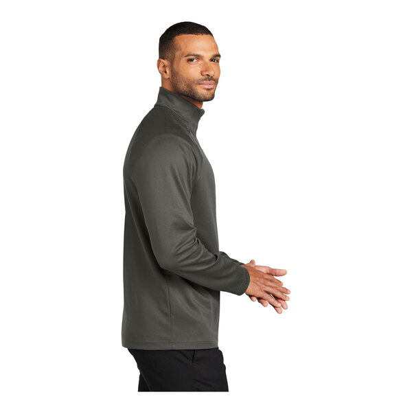 A person wearing a gray Port Authority quarter-zip sweatshirt.