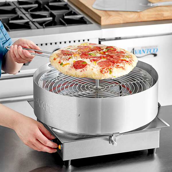 A woman using LK Packaging Pizza Capping Film to cover a pizza on a round metal device.