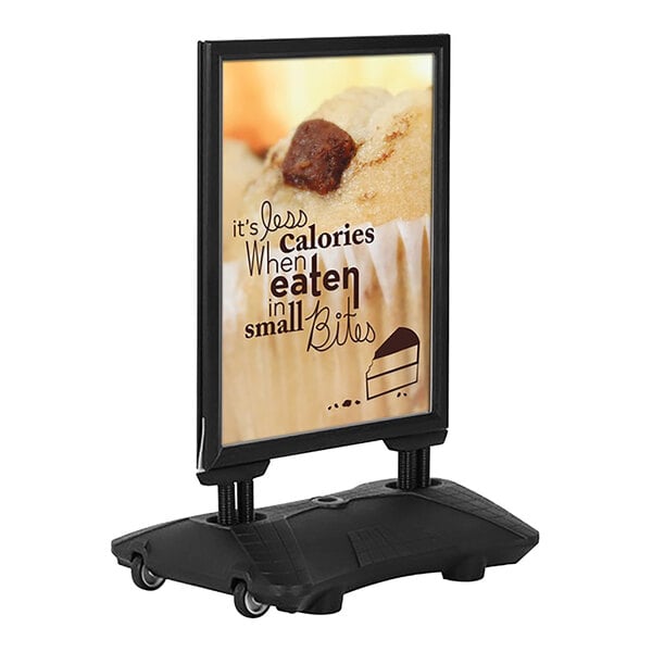 A silver MT Displays sign board on a gray Newtech water base with a black and white sign with a picture of a cupcake.