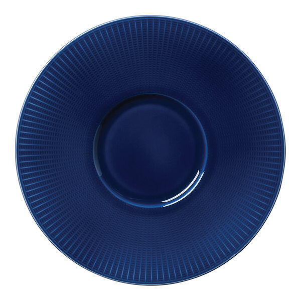 A close-up of a Steelite Willow Azure Gourmet Plate with a blue and white spiral pattern and a hole in the middle.