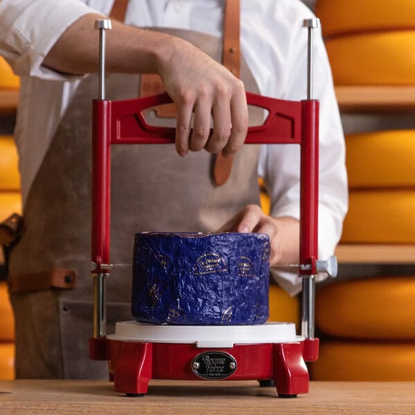 A man using a Boska RoqueForce red cheese cutter to cut cheese.