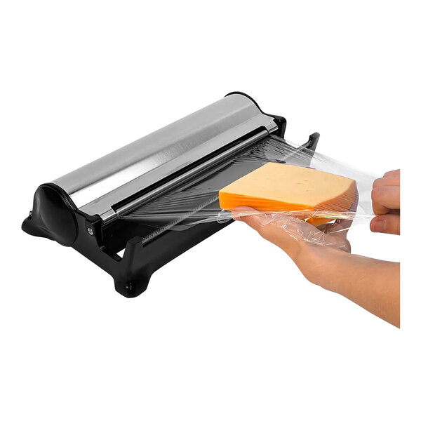 A person using a Boska black foil dispenser to cut plastic wrapped cheese.
