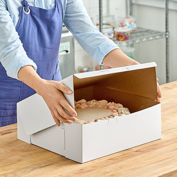 A woman opening a white Southern Champion cake box.