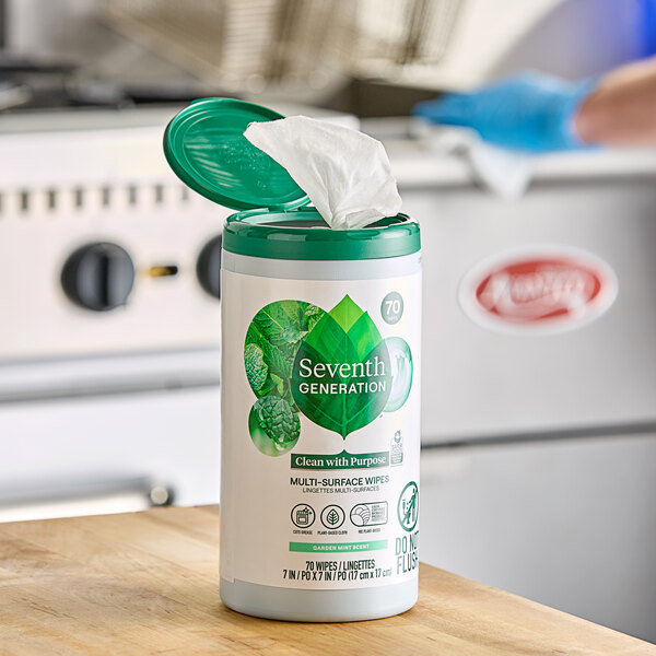 A white container of Seventh Generation multi-surface wipes with a green lid.